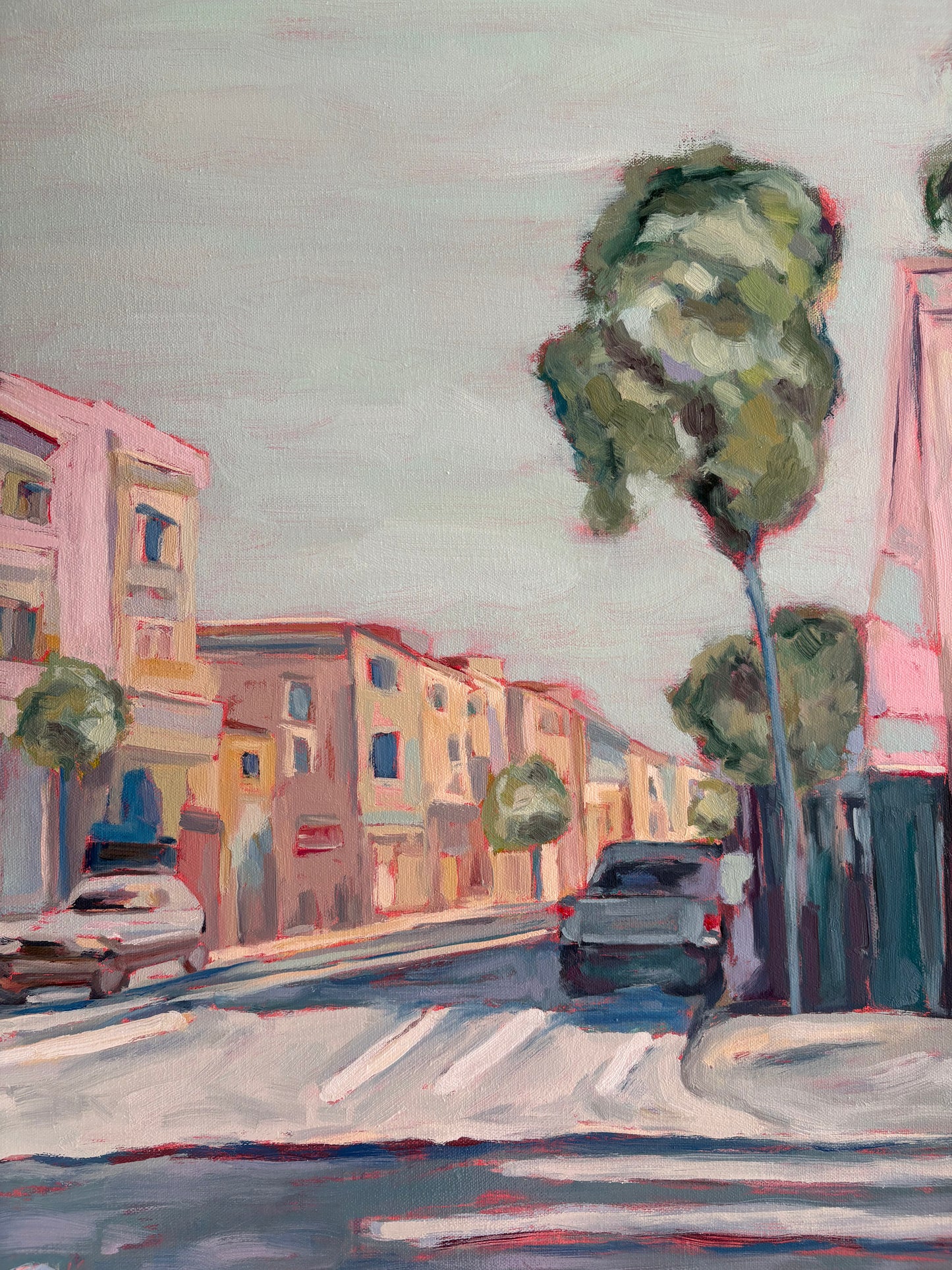 Close up of a painting of a street scene with buildings, cars, and trees.